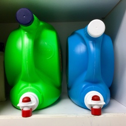 Laundry detergent and fabric softener dispensers with lids attached.