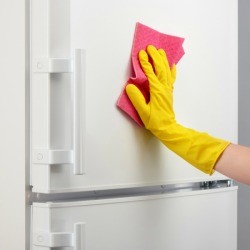 Wiping down the front of refrigerator to clean off permanent marker