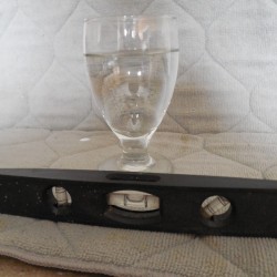 A water glass full of water, being compared to a level.