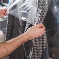 Coat being covered in a dry cleaning bag.