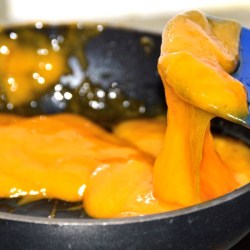 Melted cheese in a pan for topping a burger. 