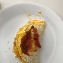 An omelet on a plate with salsa on top.