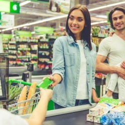 Family paying for groceries at supermarket