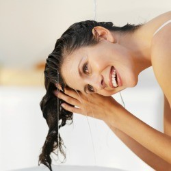Woman bending over to wash hair.