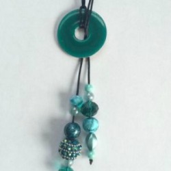 A lariat necklace with a decorated washer in the middle. 