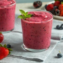 Berry Smoothie with blueberries and strawberries in the background