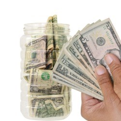 Hands holding cash to be put away for savings