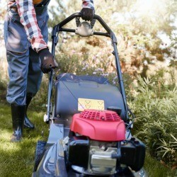 Man pulling start cord on lawn mower