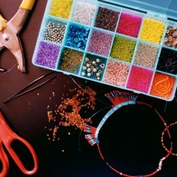Organized craft beads with scissors on a wooden table