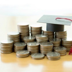 Graduation hat on top of a pile of coins.