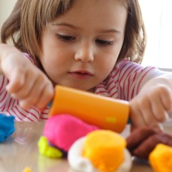 Child playing with many colors of Playdough