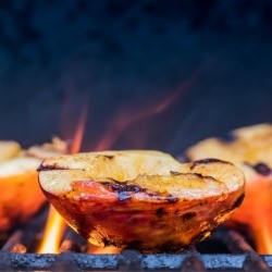 Peaches being grilled on a BBQ.