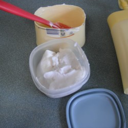 Putting extra lotion in a plastic container.
