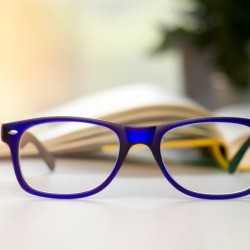 Stylish blue glasses on a blur background.