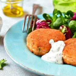 Salmon Patties on a blue plate with greens.