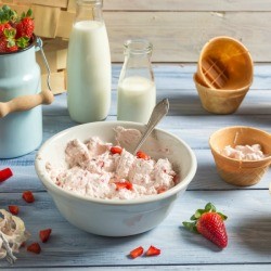 Cream and strawberry treat put in ice cream cone bowls.