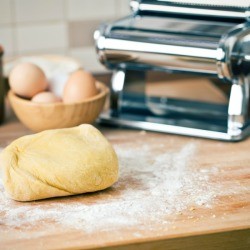 Ball of noodle dough on a floured surface.