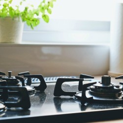 Gas stove with sunlight coming through the window.