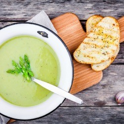 Asparagus Soup in a bowl with piece of bread.