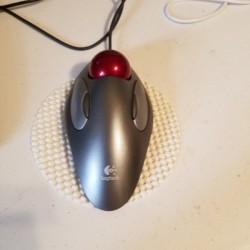A white coaster being used under a computer mouse.