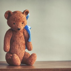 Stuffed teddy bear sitting on a table.