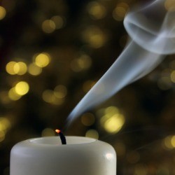 White votive candle recently extinguished. 