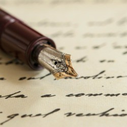 Fountain pen on a paper with writing.