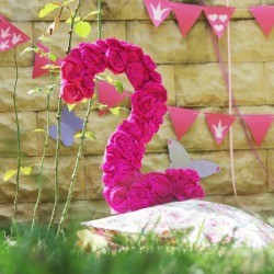 Number 2 party decoration covered in pink flowers.