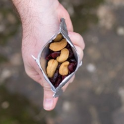 Hand holding a bag of trail mix.