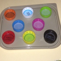 Repurpose Old Food and Storage Lids for Paint Palettes - colored soda and water bottle caps on a squarish container lid as another option