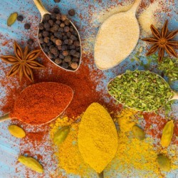 A selection of different spices, both powdered and whole.