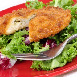 Stuffed, breaded chicken breast on a bed of lettuce.