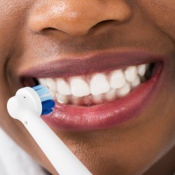 Woman brushing her white teeth.