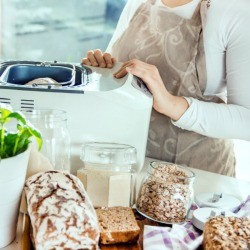 Woman making bread in a bread machine.
