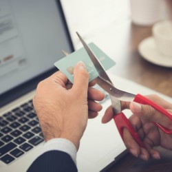 A man cutting up his credit cards.
