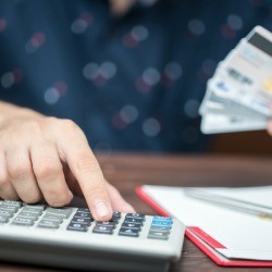 Person with credit cards and a calculator.