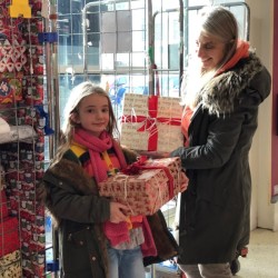 A mother and child choosing gifts from a donation site.
