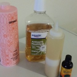 A bottle of mouthwash next to a bottle of shampoo.