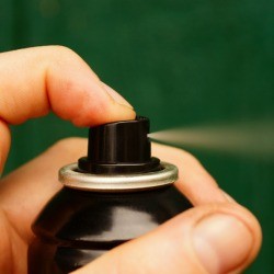 Hand spraying hairspray.