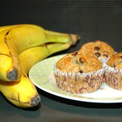 chocolate chip muffins on plate next to bunch of bananas