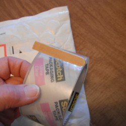 Securing the End of Packaging Tape - Popsicle stick marking the end of a roll of packing tape.
