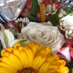 A floral arrangement with a straw for watering.