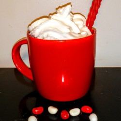 A licorice straw in a cup of hot chocolate.