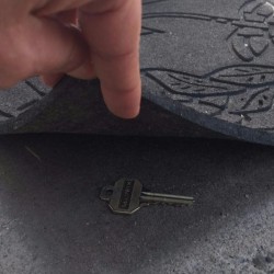 A house key hidden under a door mat.
