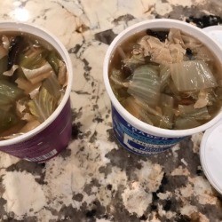 Two recycled food containers with leftover soup stored inside.