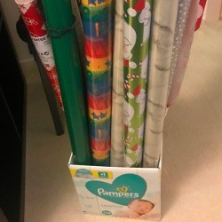 Long rolls of wrapping paper stored in a recycled cardboard box.