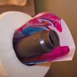 A paper scented perfume sample inside a roll of toilet paper. 