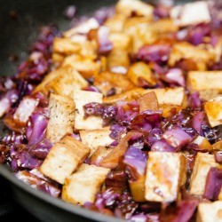 A wok with tofu and vegetables being stir fried.