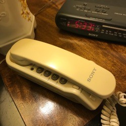 A landline telephone on a nightstand.