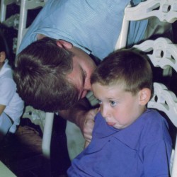 A father talking to his son at a party.